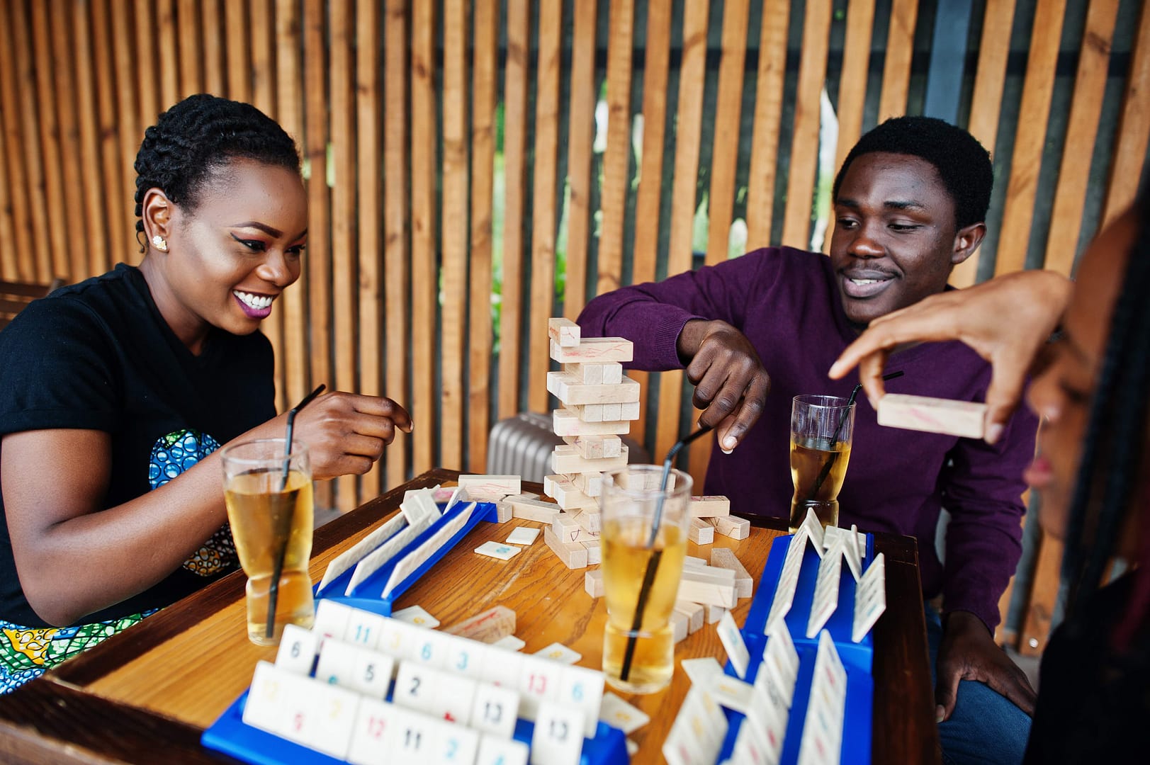 Group of three african american friends playing table games.