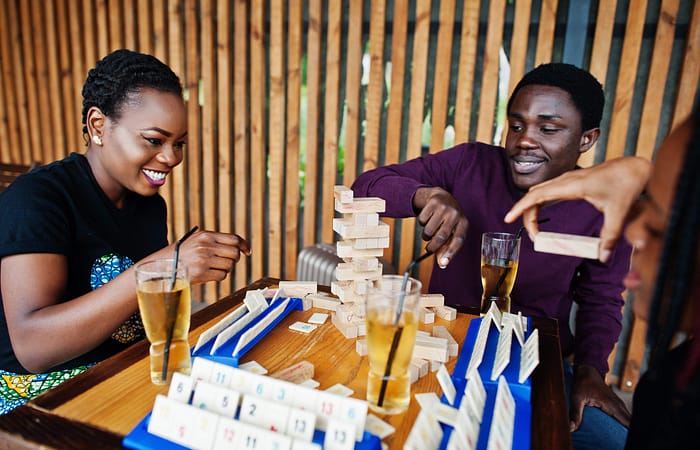 Group of three african american friends playing table games.